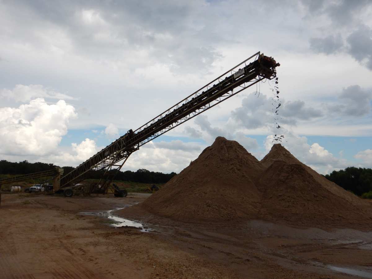 A telescoping conveyor delivers washed and sized sand particles to the stockpiles.